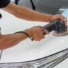 ポリッシャーとバフで車のボンネットを研磨している様子