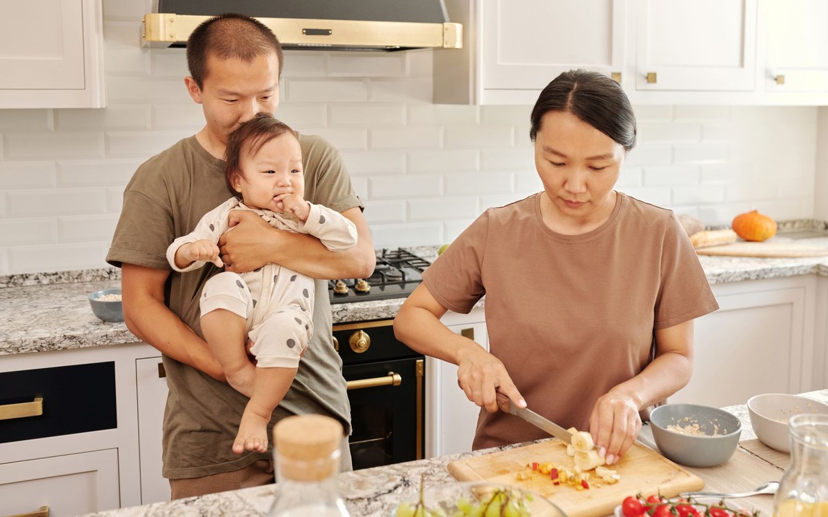 キッチンで子どもと一緒に食事の準備をする家族