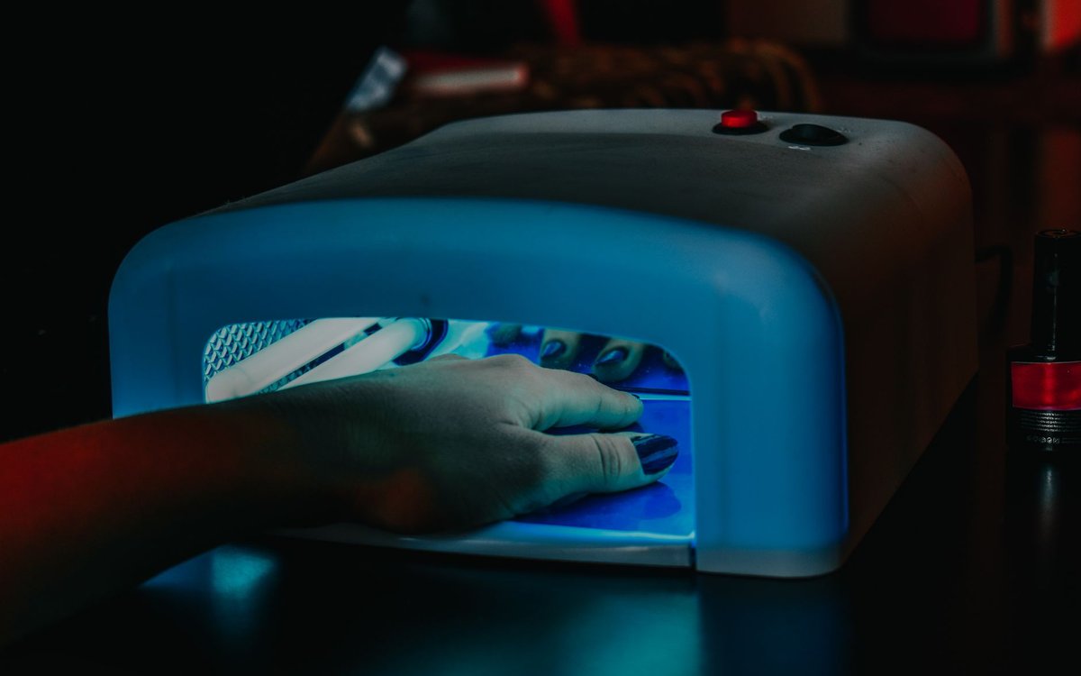 ジェルネイルを自宅で始める道具一式のイメージ。LEDライトで指先のジェルを硬化している様子