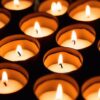 温かな灯りをともしたティーライトキャンドルが並ぶ様子（敬老の日に贈る火を使わないLEDキャンドルのイメージ）