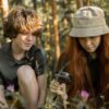 虫めがねで森の植物を観察する子供たち（理科知育アプリ「りかのもり」イメージ）