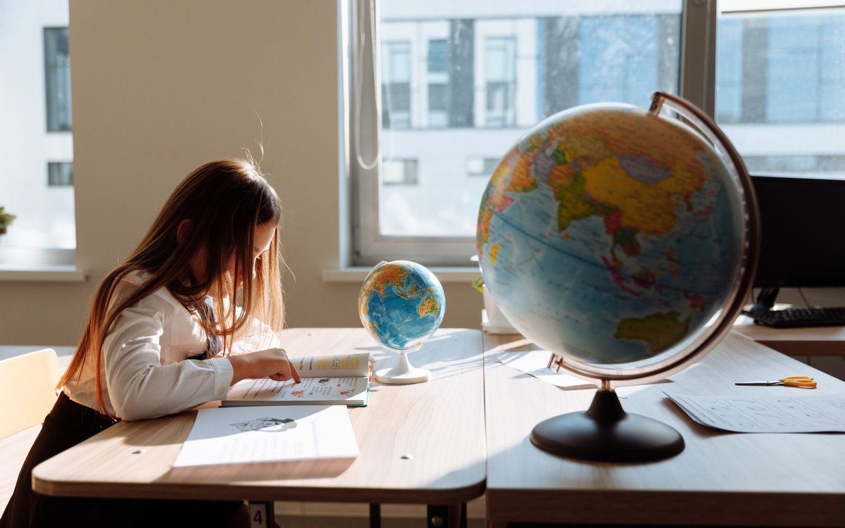 地球儀のそばで勉強する小学生