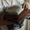 秋の衣替えでたたんだニットを抱える様子