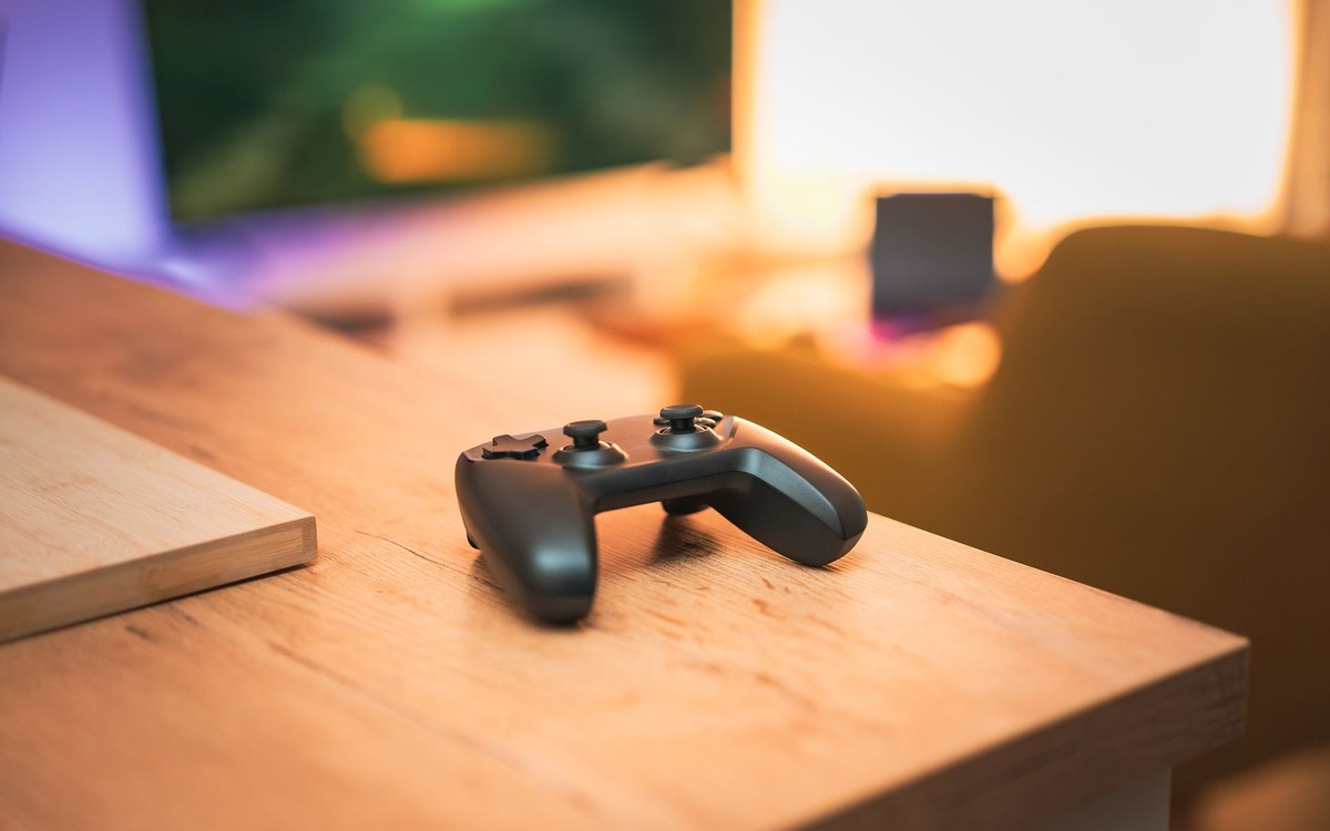木の机の上に置かれたゲームのコントローラー