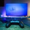 リビングのテーブルに置かれたゲームのコントローラーとスマホ、タブレット